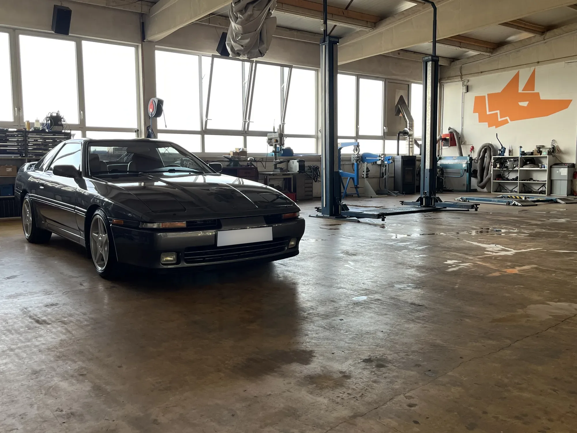 Toyota Supra in der Halle, an der Wand das Fuchs-Logo