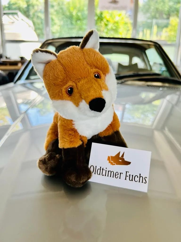 Plüsch-Fuchs mit dem Oldtimer-Fuchs-Schild auf einer Motorhaube